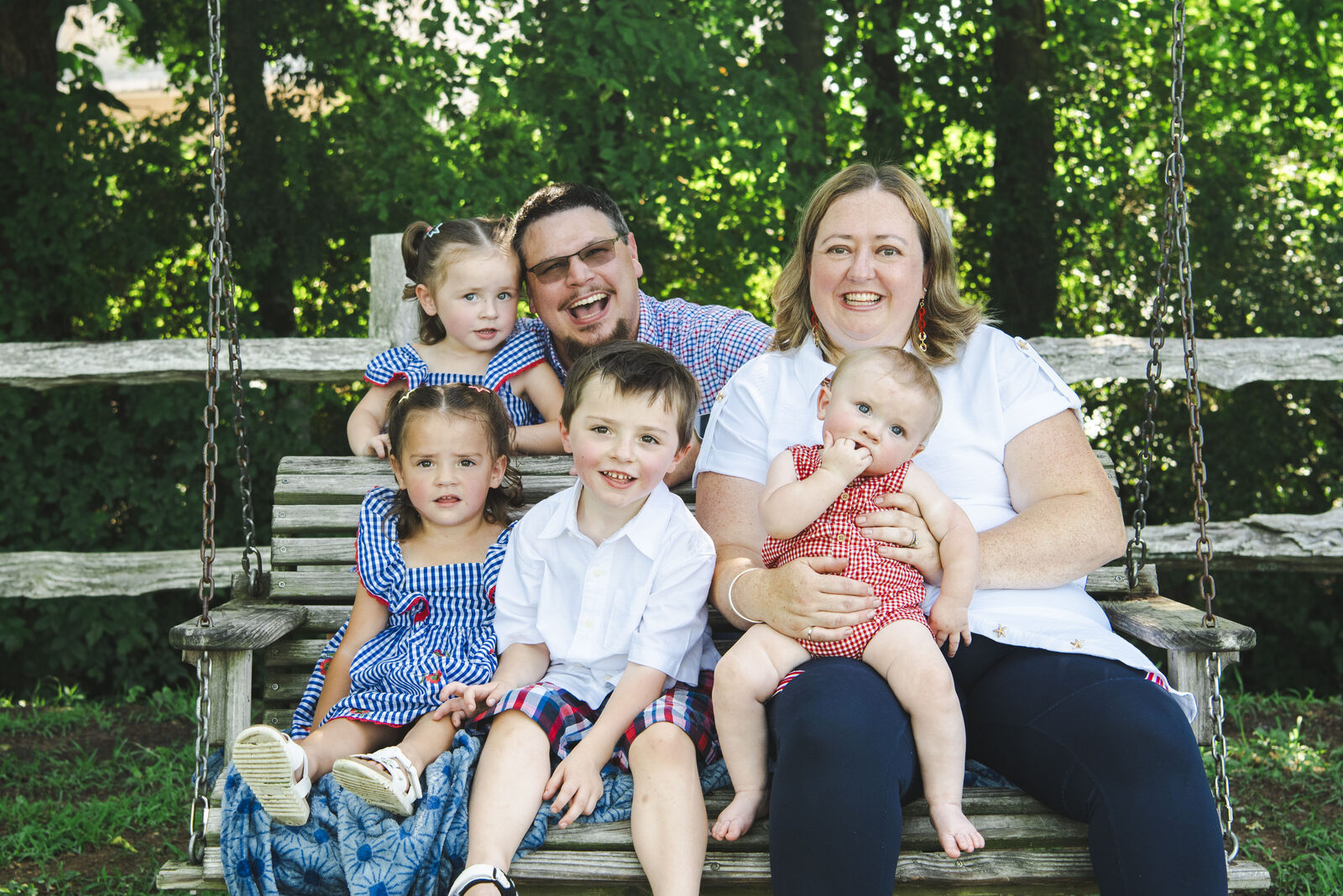 Chris Twombley with his family on a porch swing.
